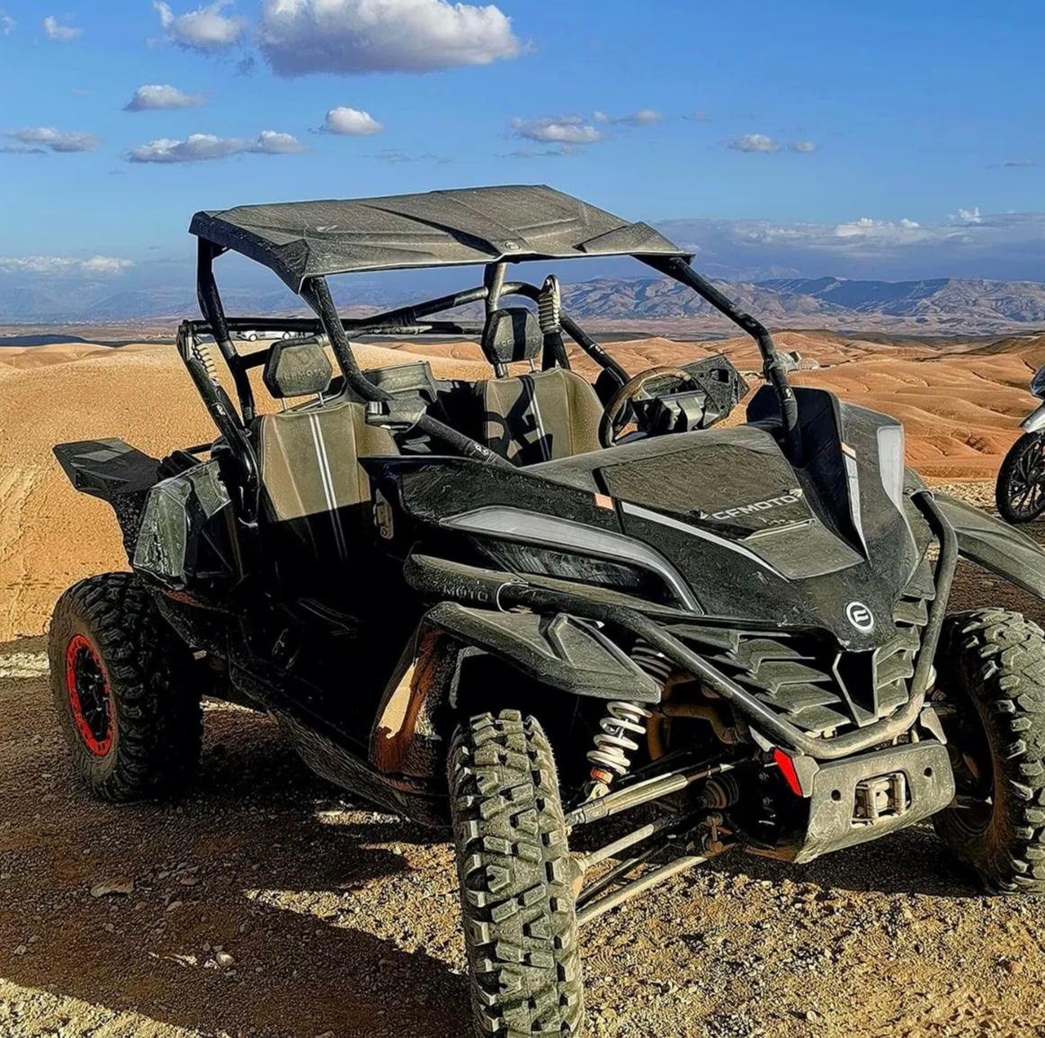Two people side by side in a buggy in the Agafay desert